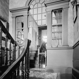 Connecting door opening hidden within Palladian window at staircase landing